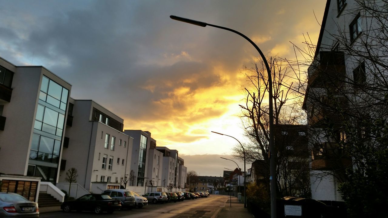 transportation, car, land vehicle, building exterior, mode of transport, architecture, sky, built structure, sunset, street, cloud - sky, road, city, the way forward, cloudy, parking, tree, house, parked, stationary