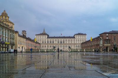 Buildings in city against cloudy sky