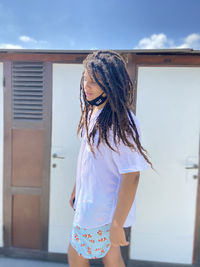 Young woman standing against white wall