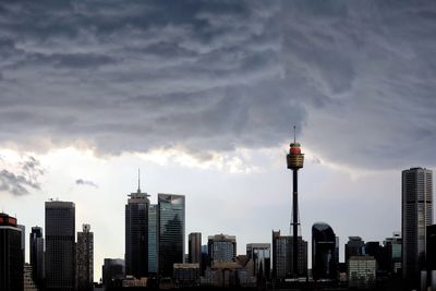 Buildings in city against cloudy sky