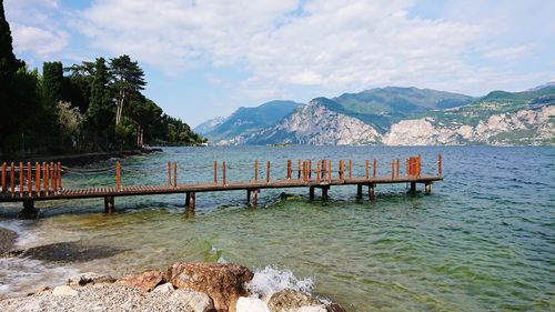 Scenic view of lake by mountains against sky