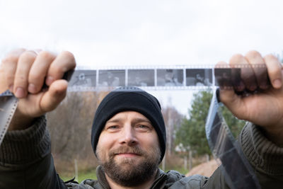 Cropped hand of man standing against sky