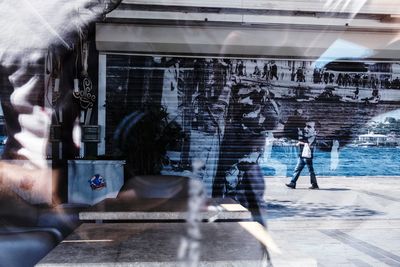 People walking by building in city