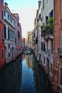 Canal amidst buildings against clear sky