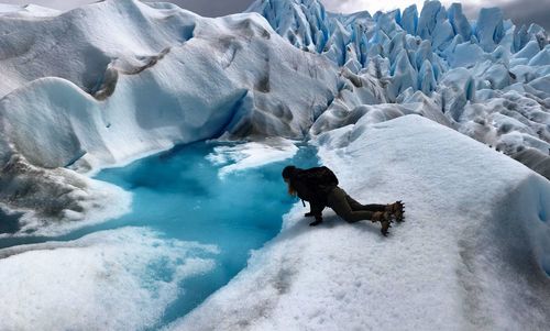 Woman lying on glacier
