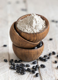 Wooden bowls with black beans flour and dried beans closeup