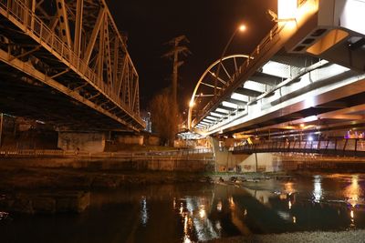 Illuminated bridge over river at night