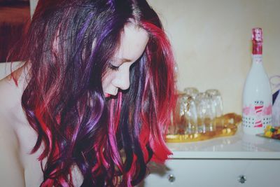 Side view of beautiful woman with dyed hair at home