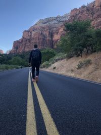 Rear view of man on road against sky