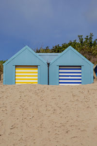 Beach hut against clear blue sky