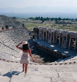 Full length rear view of woman walking towards historical building