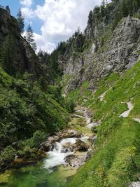 Scenic view of waterfall against sky
