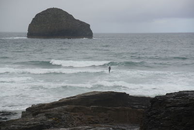 Rock formation on beach against sky