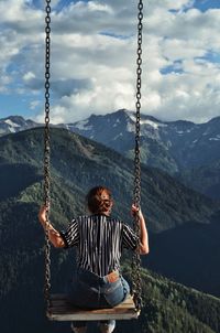 Rear view of woman sitting on swing at playground