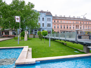 View of swimming pool by buildings against sky