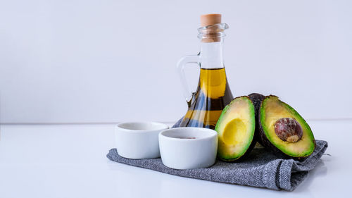 Olive oil in glass bottle with sesame and flax seeds. fresh ripe hass avocado. healthy eating. 