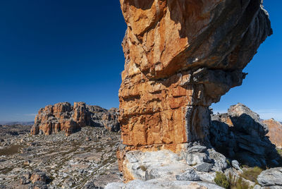 Rock formations against clear blue sky