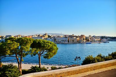 City by sea against clear blue sky