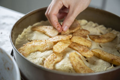 Close-up of man making an apple cake