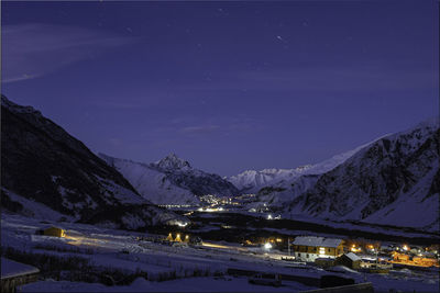 Illuminated snowcapped mountains against sky at night