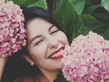 Portrait of woman on pink flowering plant