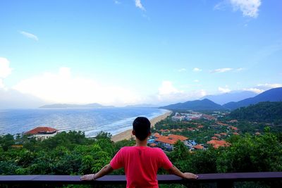 Rear view of woman looking at sea against sky