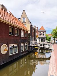 Reflection of buildings in canal against sky