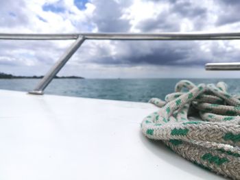 Close-up of rope tied to sea against sky