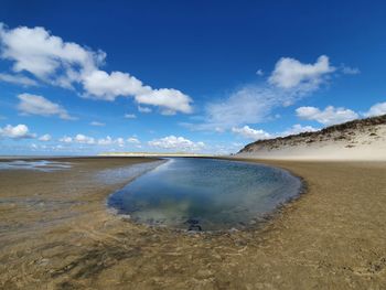 Scenic view of beach against blue sky