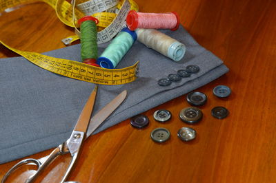 High angle view of sewing items with fabric on wooden table