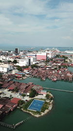 High angle view of town by sea against sky