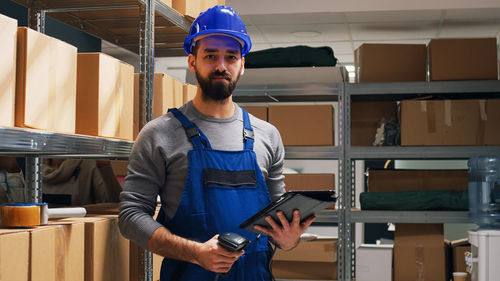 Portrait of young man standing in factory