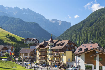 Houses amidst buildings and mountains against sky