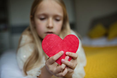 Defocused image of girl holding heart shape