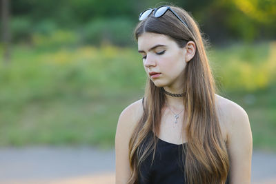 Portrait of young woman standing against lake