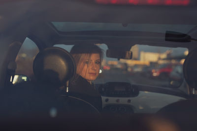 Portrait of young woman in car