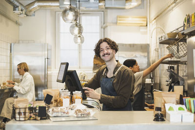 Portrait of male owner working on computer in store