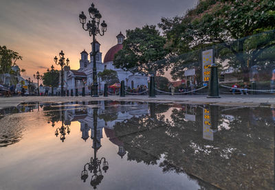 Reflection of building in puddle on lake