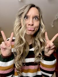 Portrait of smiling young woman against wall