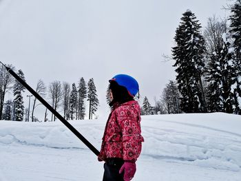 Rear view of man on snow covered field against sky