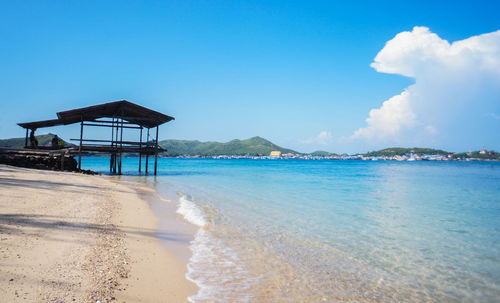 Lifeguard hut on beach against blue sky
