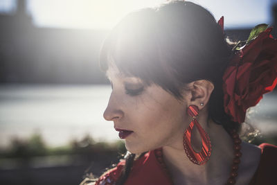 Close-up of young woman wearing jewelries during sunny day