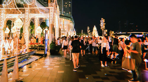 Group of people walking in illuminated building at night