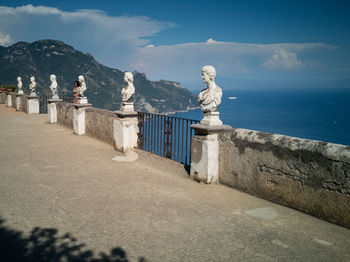 Statue by sea against sky