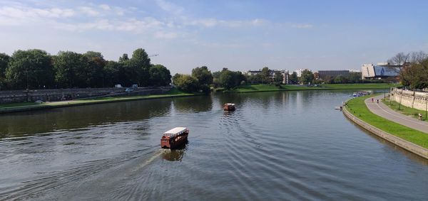 Scenic view of lake against sky in city