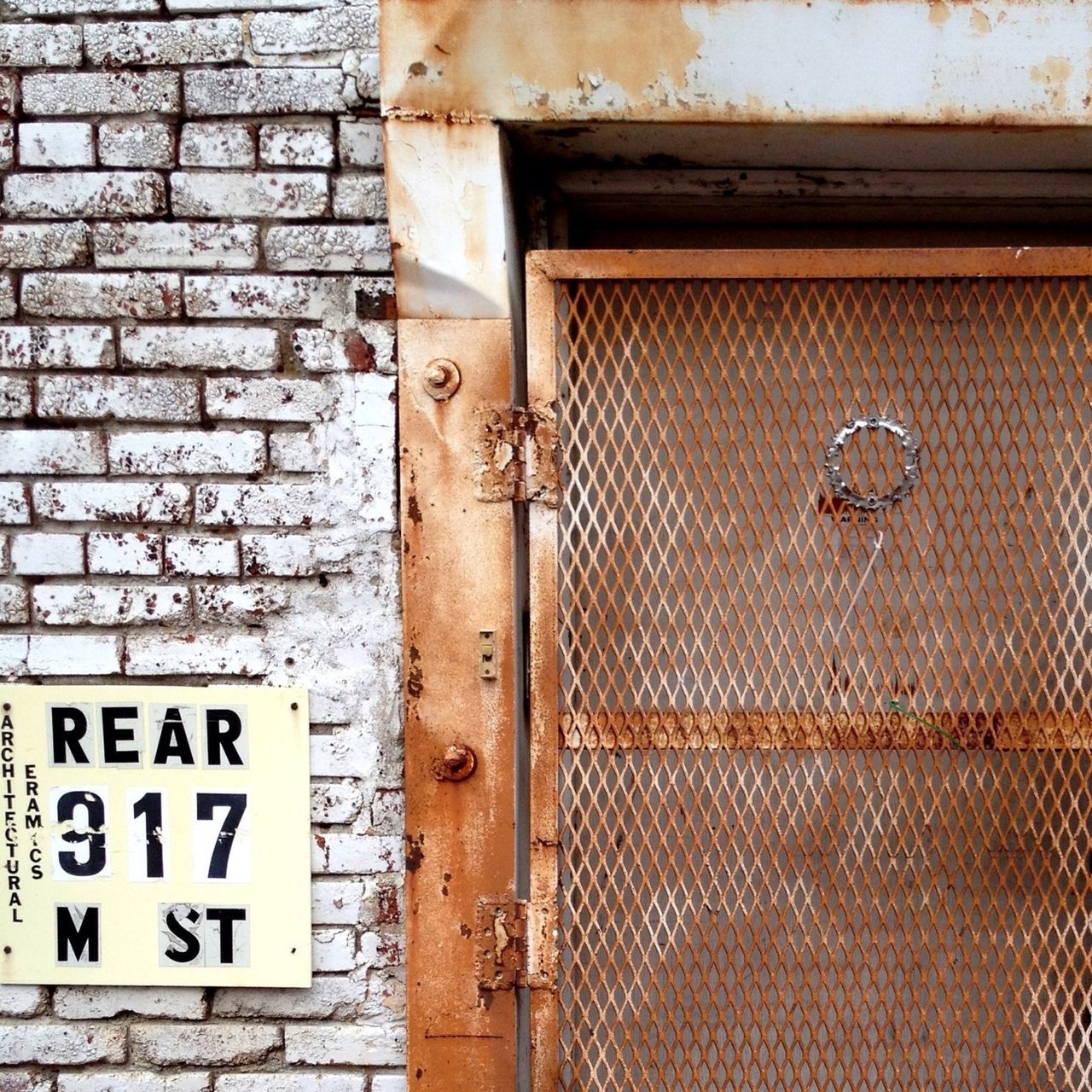 text, western script, communication, building exterior, architecture, built structure, safety, door, wall - building feature, closed, protection, metal, rusty, security, close-up, old, outdoors, day, weathered, brick wall