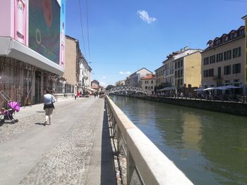 Canal amidst buildings in city against sky