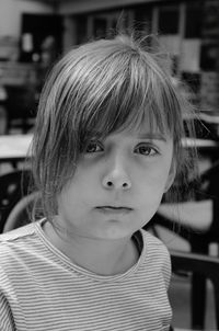 Portrait of cute girl with bangs sitting at cafe