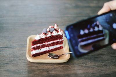 Close-up of hand holding ice cream on table