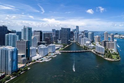 High angle view of cityscape by sea against sky